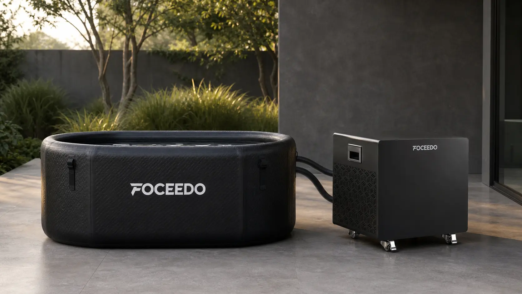Properly installed Foceedo cold plunge chiller connected to a black inflatable ice bath tub via hoses on a modern outdoor patio.